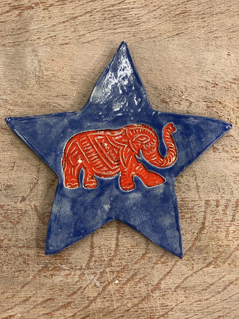 Une étoile en poterie avec comme illustration un éléphant